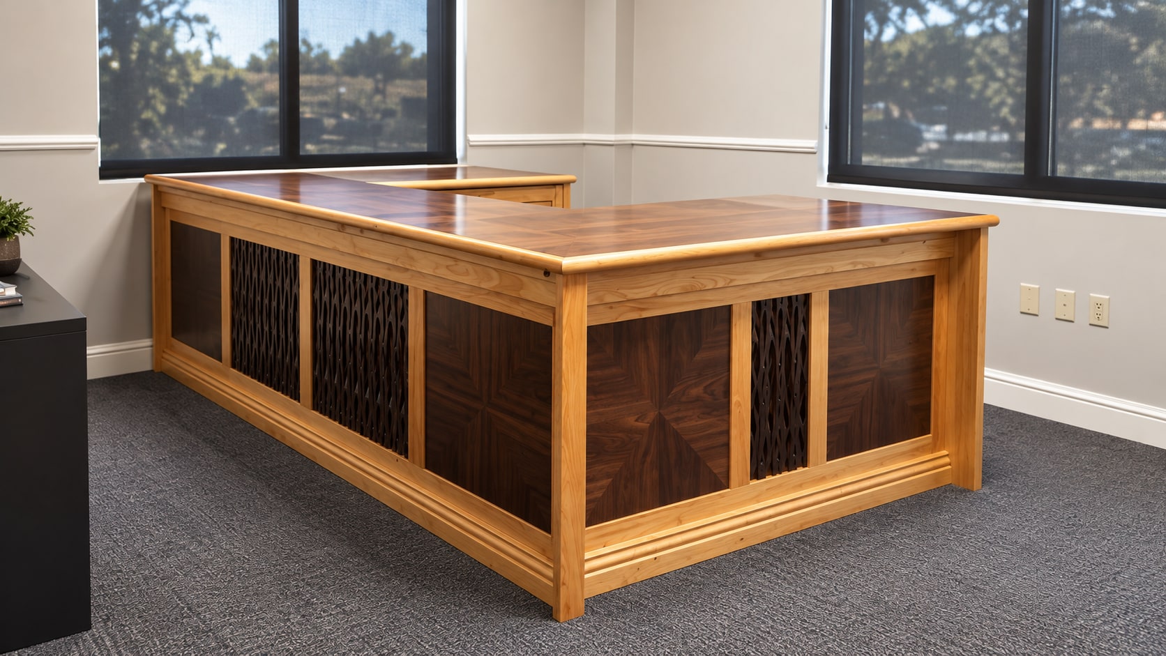 Large made-to-measure wood desk with decorative panel inserts in a bright office