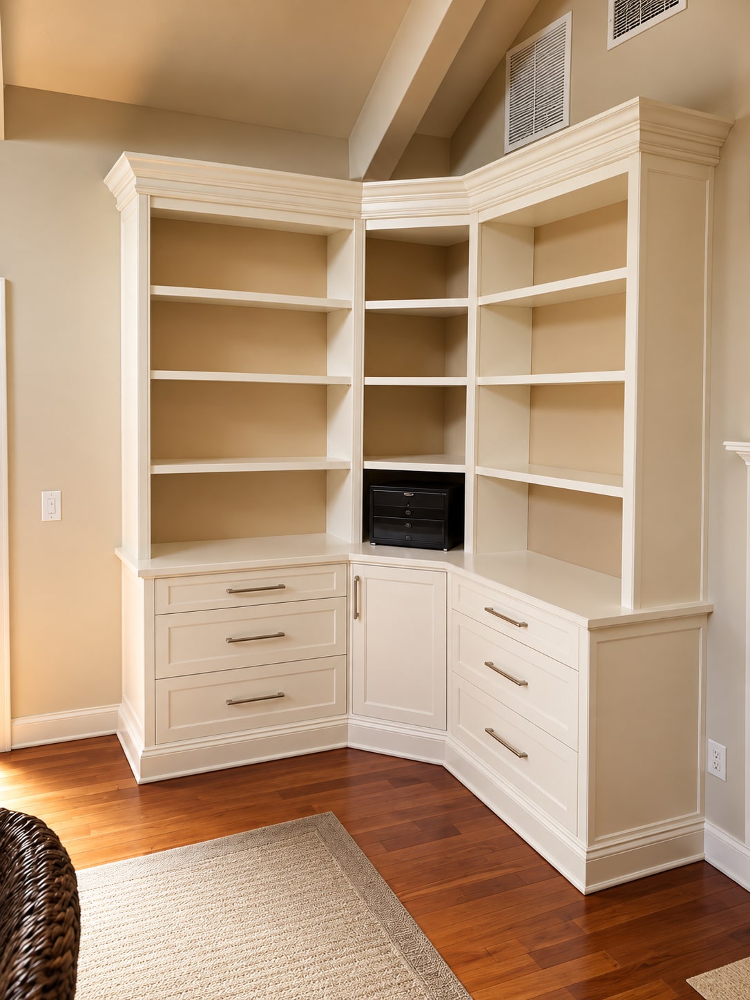Cream corner built-in cabinetry with open shelves, drawers, and a custom desk-height counter