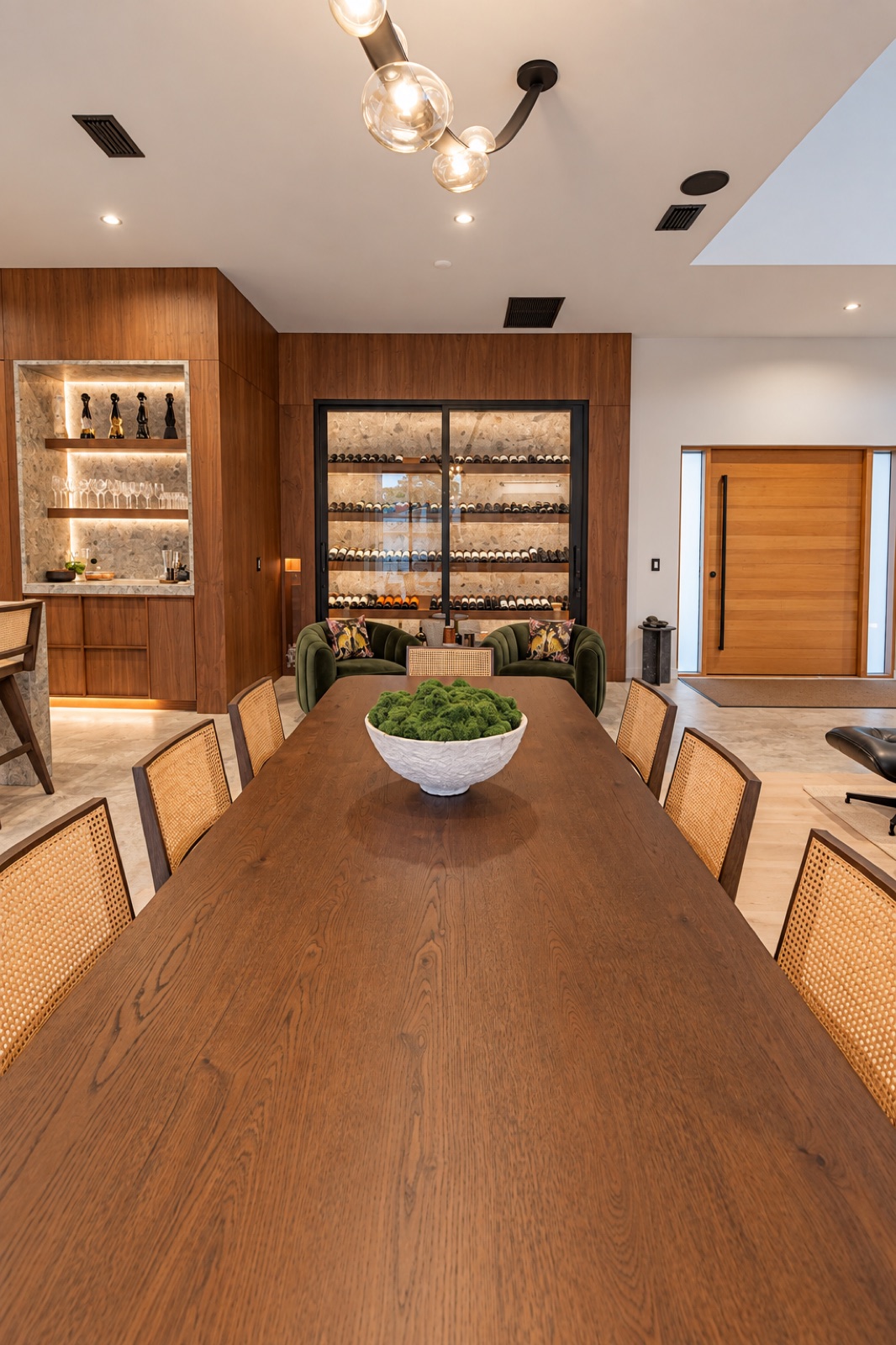 Tampa home dining room with a walnut table, integrated wine storage, and illuminated bar display