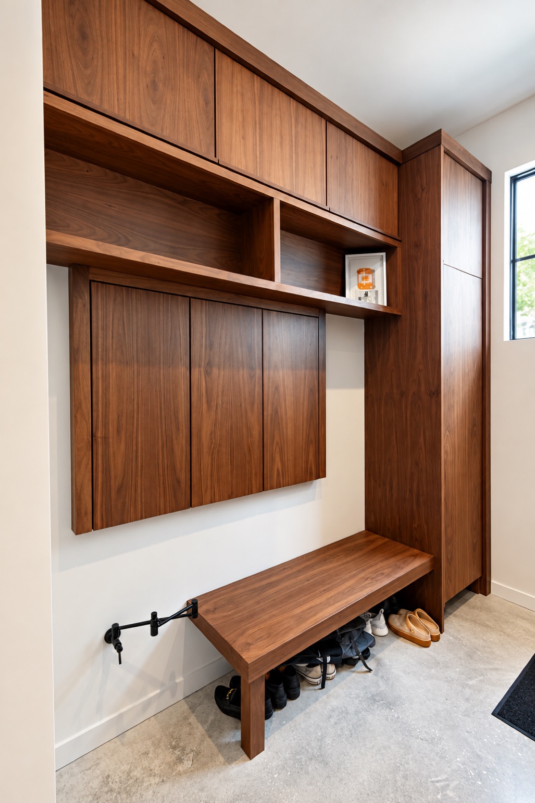 Tampa home mudroom with floor-to-ceiling walnut cabinetry, overhead storage, and a custom bench